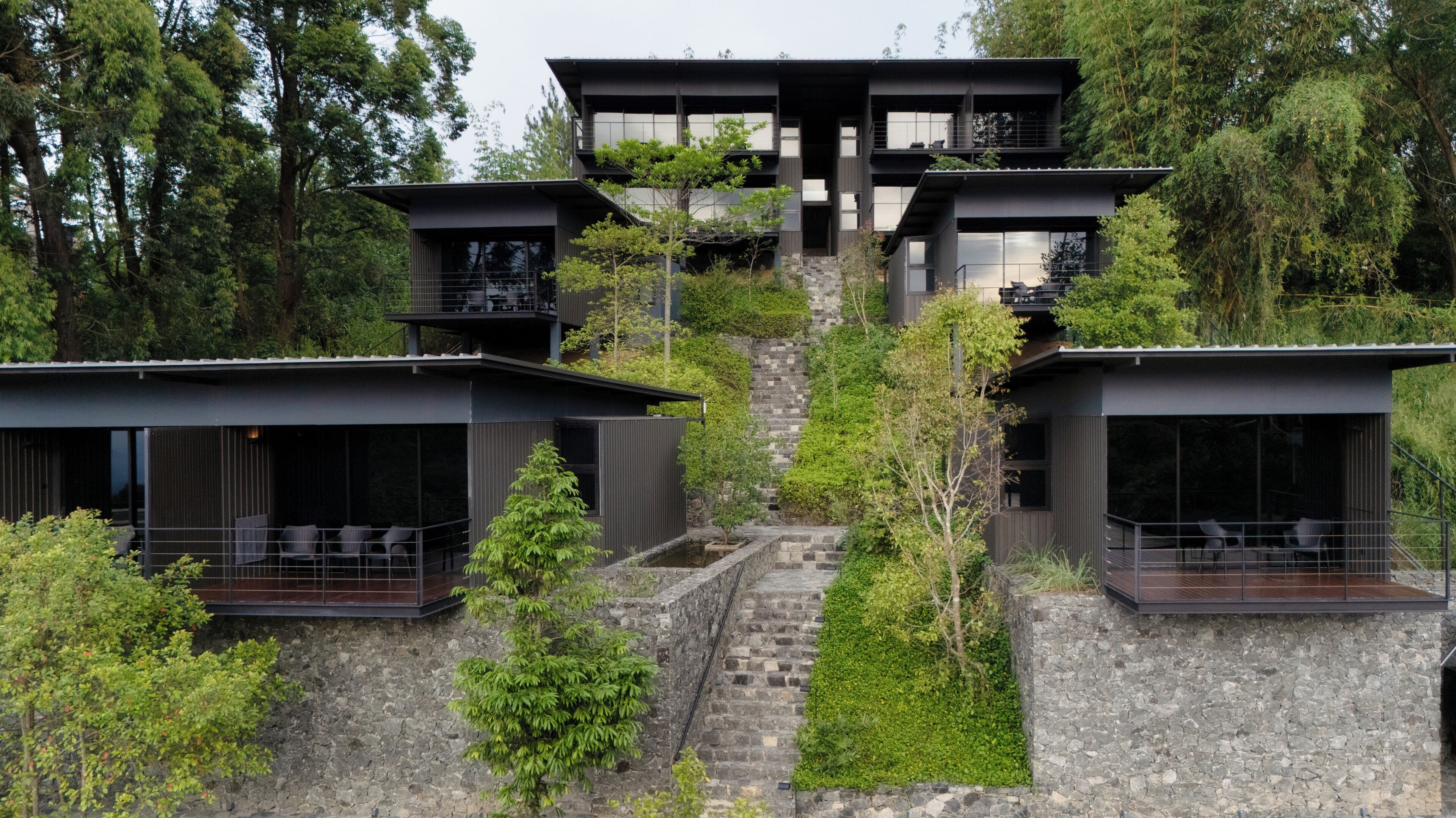 Une maison moderne à plusieurs étages, dotée d’un escalier en pierre menant à l’entrée.