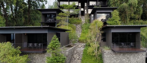A modern multi-story house with a stone staircase leading to the entrance.