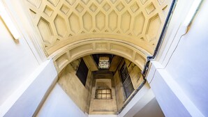 Un étroit passage voûté, doté d’un plafond orné de motifs et d’une petite fenêtre grillagée.