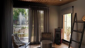 A modern room with a large window, a fireplace, and a view of the outdoors. - Lun Lodges (Chacras de Coria)