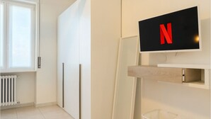 Et moderne værelse med skydedør, indbygget TV og en radiator.