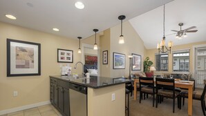 A kitchen with a central island, dining area with chairs, and a ceiling fan. - Founders Pointe 4649 Ski Mountain Condo Resort Amenities Walk to Ski Lifts (Winter Park)