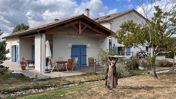 Una casa con un patio, un tavolo da pranzo e sedie.