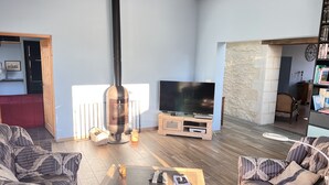 Un soggiorno con camino, televisore e divani decorati.