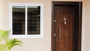 A wooden door with a keyhole and a window with a white frame. - Fully furnished and spacious 2bedroom House in Accra (Nii Okaiman East)