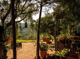Un área de estar al aire libre de estilo rústico con un letrero que indica la dirección hacia un restaurante.