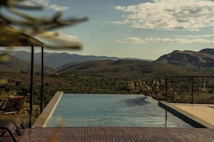 Una piscina infinita con vistas a montañas.