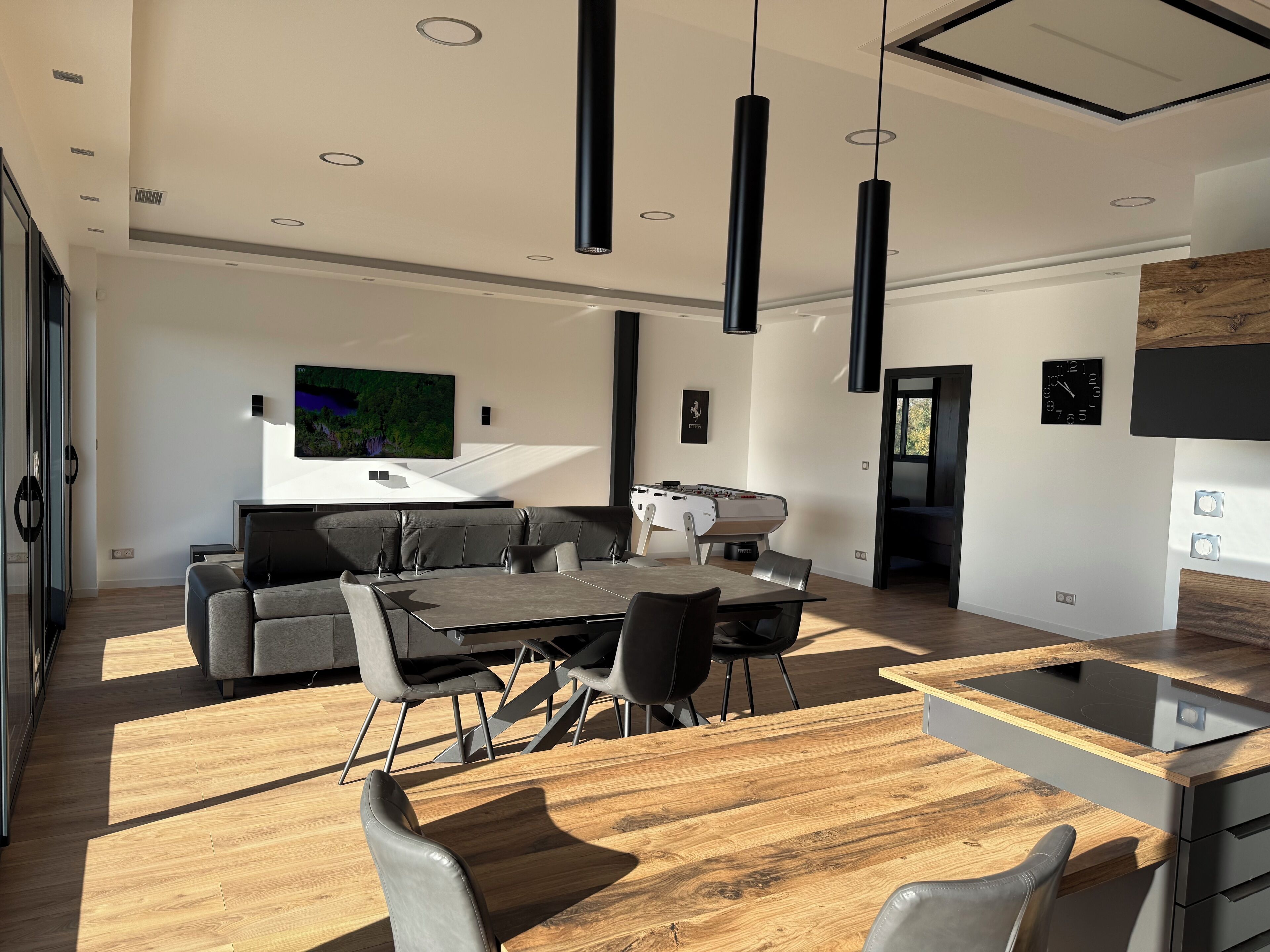 A modern kitchen with a wooden countertop, a built-in oven, and a large window.