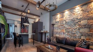 Ein modernes Wohnzimmer mit einer Steinwand, einem Ledersofa und einem Holztisch.