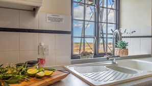 Una cucina con lavello, una finestra vista e un cartello per la raccolta differenziata.
