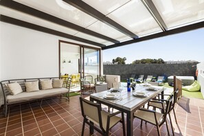 Een modern buitenontbijtgedeelte met een tafel voor twee personen, een bank en uitzicht op de skyline.