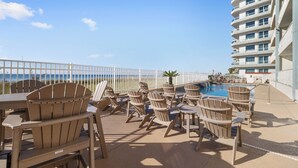 Un espace aménagé au bord de la piscine, avec des fauteuils Adirondack et une vue sur l’océan.