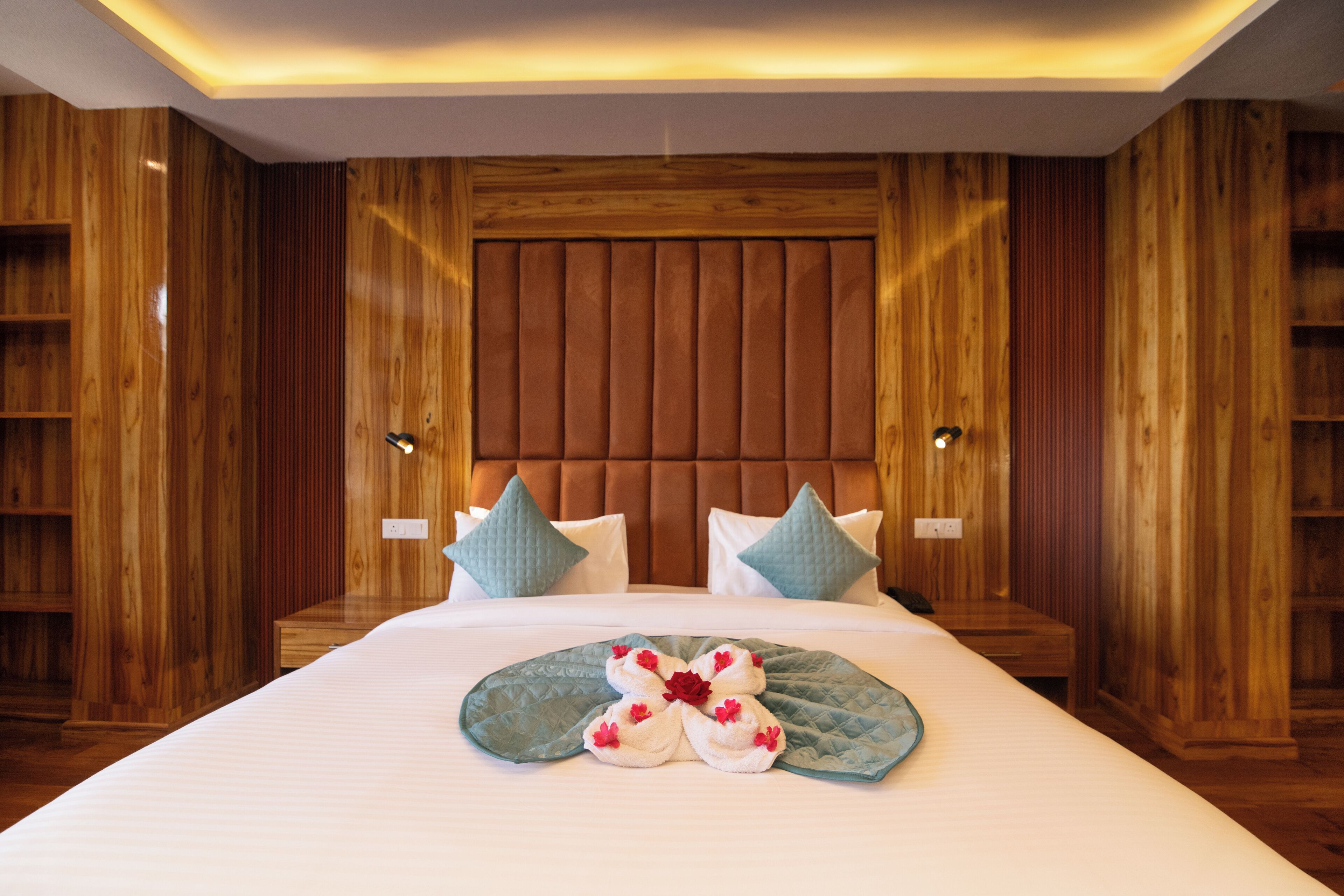 Une chambre d’hôtel avec un grand lit, des lambris en bois et une tête de lit dotée de lattes verticales.