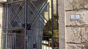Un edificio de piedra con una reja metálica que presenta un diseño geométrico.