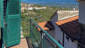 Un balcón con vistas a un pueblo y montañas.