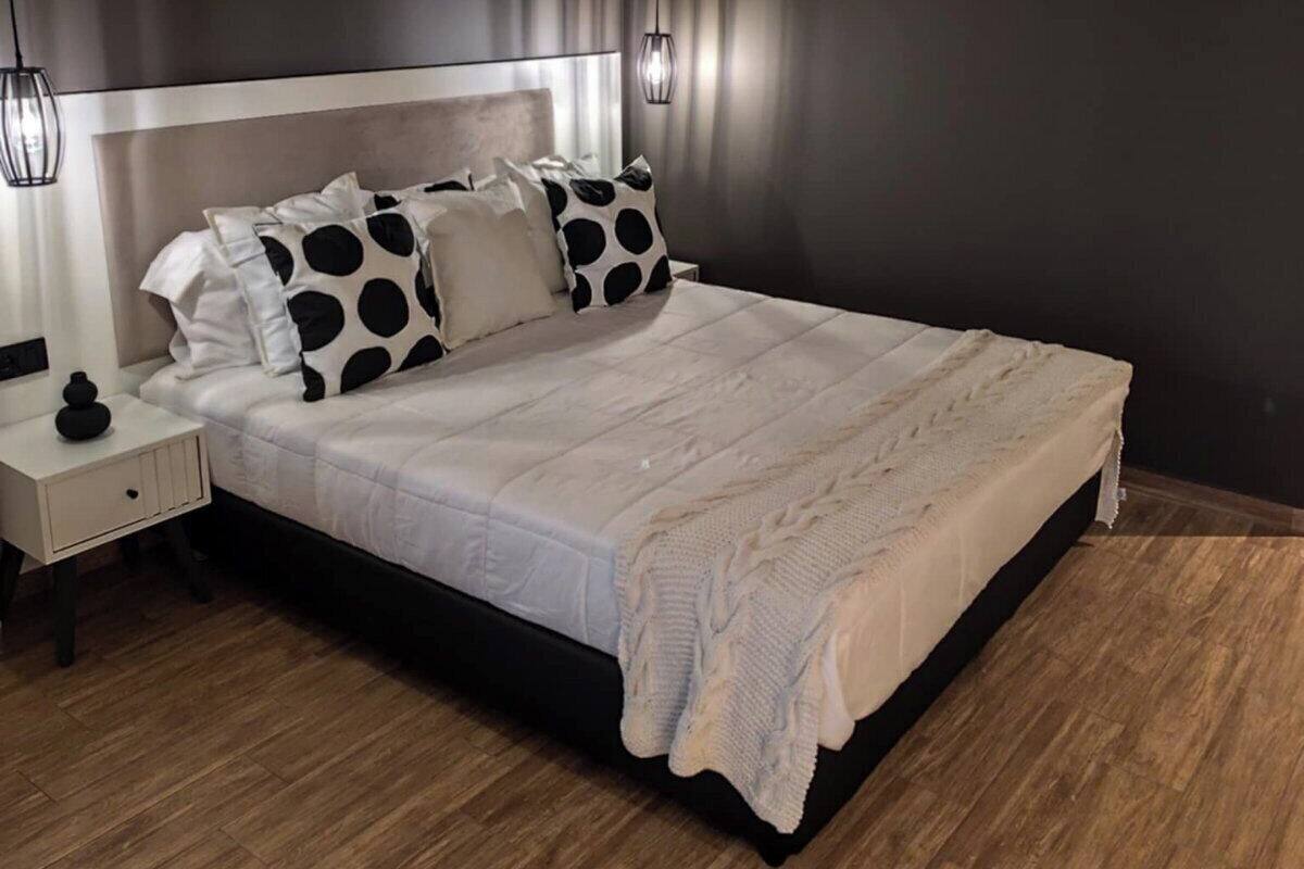 Ein modernes Schlafzimmer mit einem großen Bett, einem Nachttisch und einer Pendelleuchte.