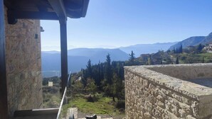 Un edificio de piedra con vistas a montañas distantes y un cielo despejado.