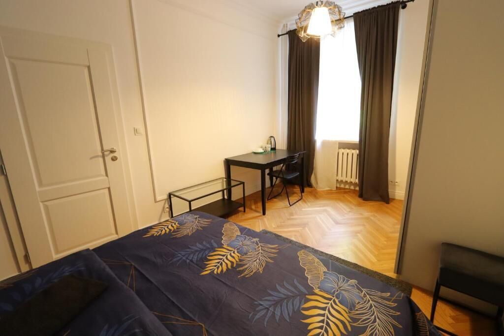 A bedroom with a bed, a desk, and a chair.