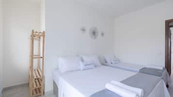 Et hotelværelse med to senge, en træhylde og dekorativ vægkunst.