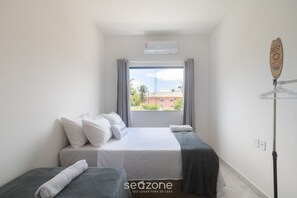 A hotel room with a bed, a window, and a view of buildings outside. - Apt 3 Bedrooms in Condo w/ Pool Csv0006 (Porto Seguro)