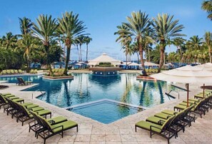 A pool area with lounge chairs and palm trees. - Spectacular  2BD Bay Vista High Floor Great View at Westin St. John (Cruz Bay)