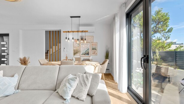 Een moderne woonkamer met een bank, een eettafel en kunstwerken.
