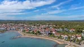 An aerial view of a coastal town with residential buildings, a beach, and boats. - Boho Beach House by Villas Guide (Vodice)