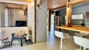 Una cucina moderna con piano di lavoro in legno, elettrodomestici in acciaio inossidabile e una zona bar.
