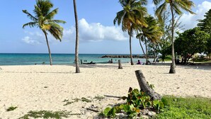 Na praia, espreguiçadeiras, toalhas de praia 