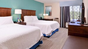 A hotel room with two beds, a desk, a TV, and a window with curtains. - Spark By Hilton Decatur (Decatur)