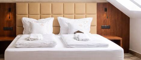 A double bed with a headboard, two bedside tables, and a skylight above.