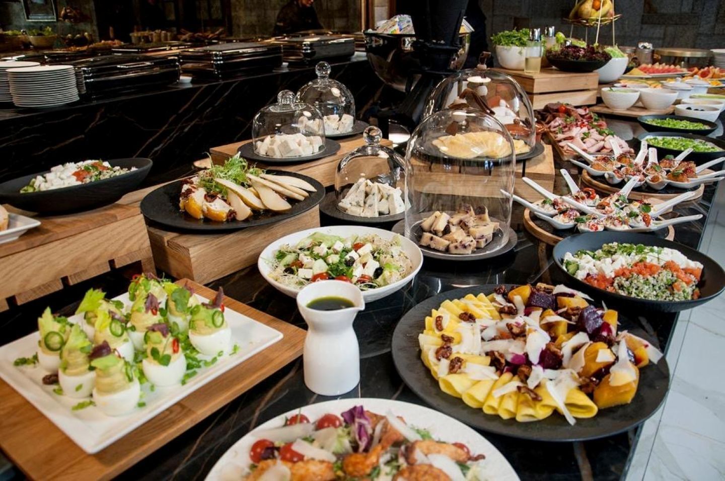 A buffet with various dishes including salads, meats, and desserts.