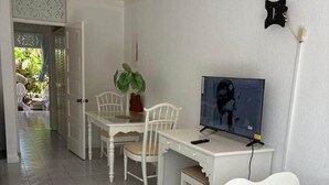 Ein Zimmer mit einem Bett, einem Schreibtisch, einem Stuhl und einem Fernseher.