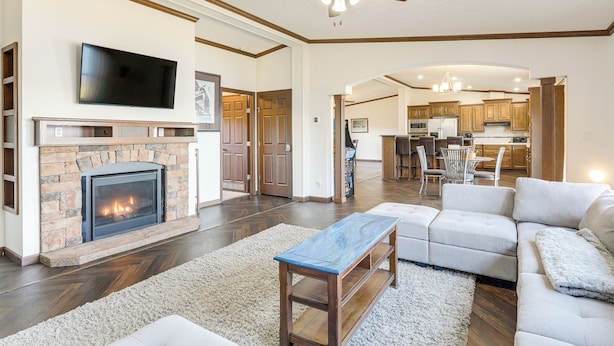 A spacious living room with a fireplace, a television, and a ceiling fan. - Fish & Relax Fireside: Mink Lake Retreat! (Buffalo)