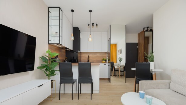Una sala de estar moderna con un televisor de pantalla plana, un sofá, una mesa de centro y un comedor con sillas y una mesa.
