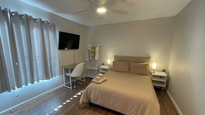 Um quarto moderno com uma cama grande, uma escrivaninha e uma cadeira.