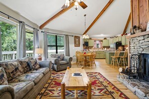 A spacious living room with a sofa, a wooden coffee table, and a fireplace. - Pet Friendly Rustic 2-bedroom chalet in charming Gatlinburg (Gatlinburg)