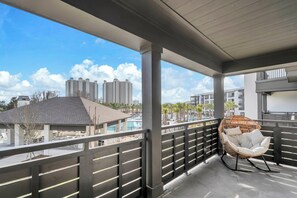 Ein Balkon mit Korbstuhl und Blick auf hohe Gebäude.