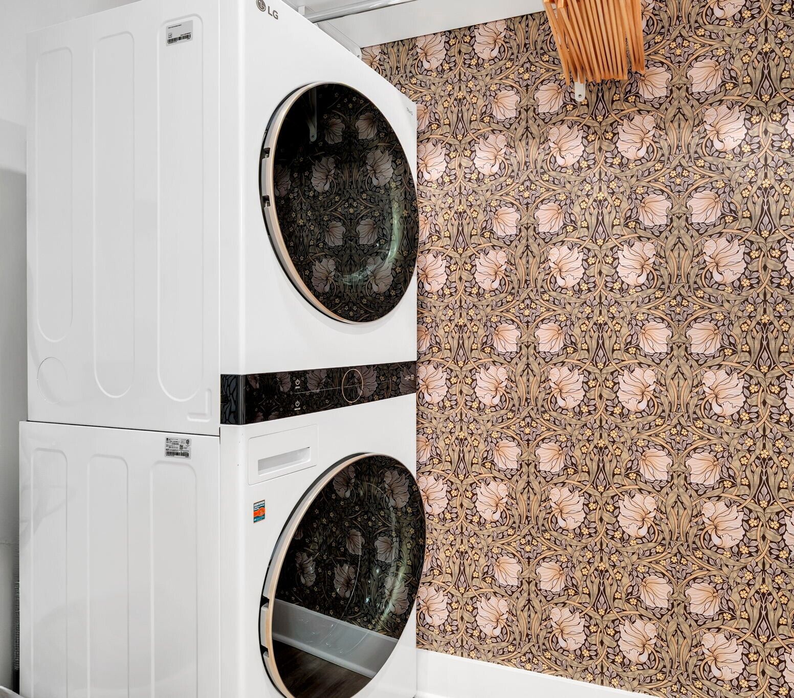 A laundry room with two white washing machines and a patterned floor.