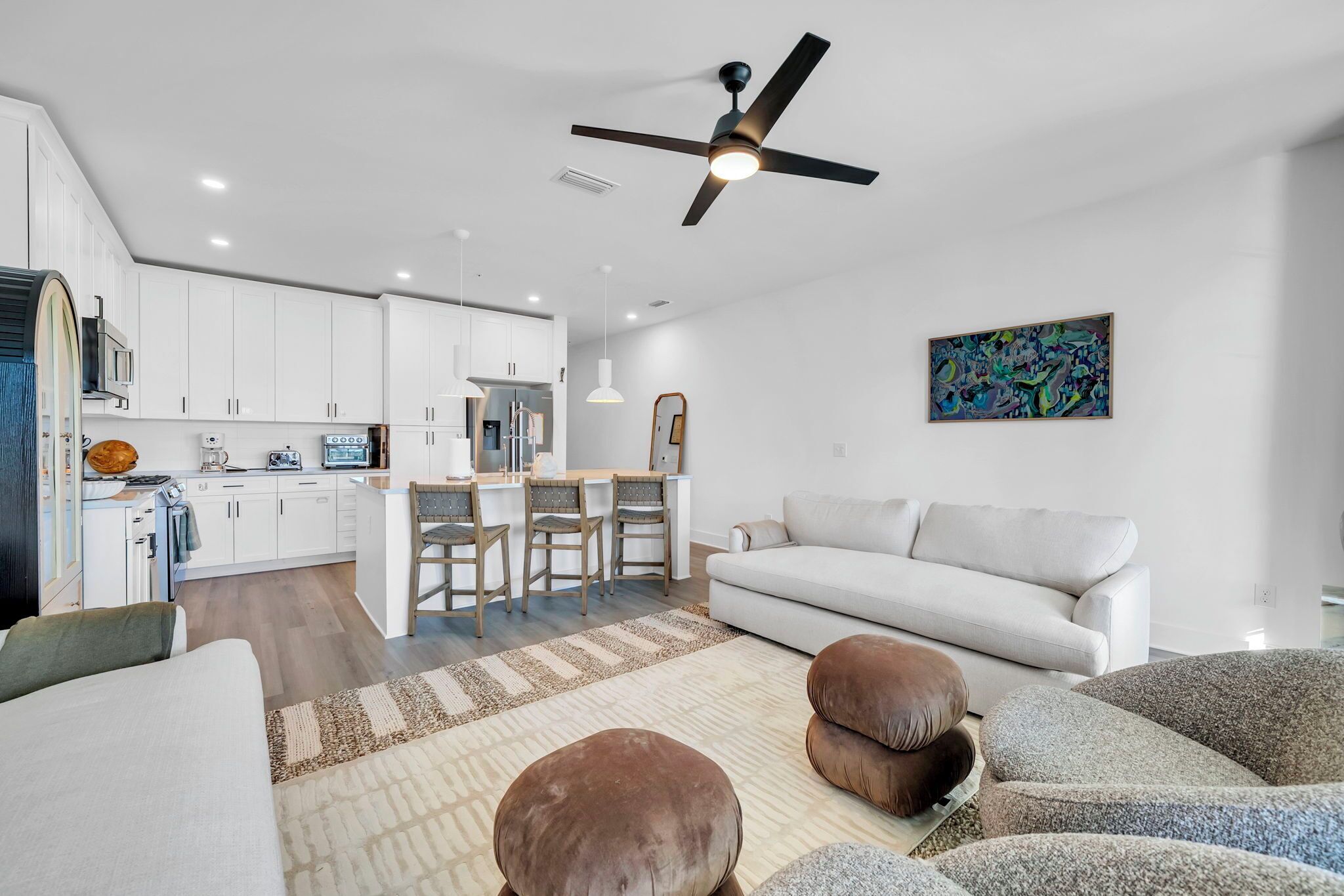 Moderni olohuone, jossa on keittiö, ruokailutila ja valkoinen sohva.