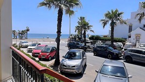 A parking area with multiple cars, palm trees, and a view of the beach and ocean. - Euromar 121 (Torrox)