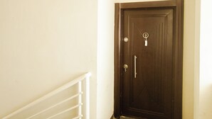 A staircase leading to a dark wooden door with a keyhole and a handle. - Spacious 3-bedroom house in Accra (Achimota)
