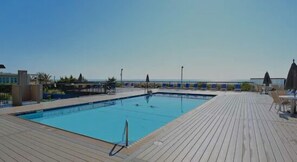 A rectangular swimming pool with a wooden deck surrounding it. - Fountainhead Towers 1604 by Seaside Vacations & Sales (Ocean City)