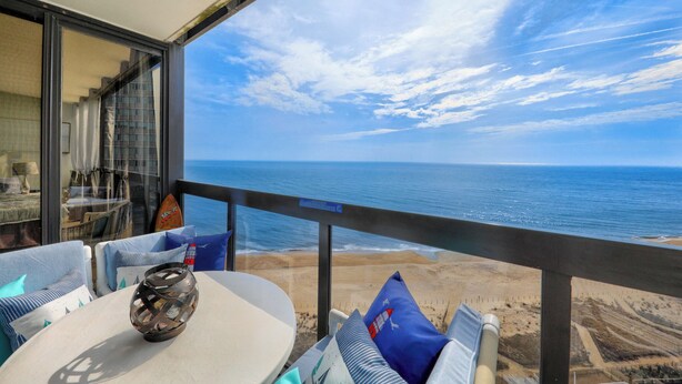 Un balcón con vista a la playa y al océano.