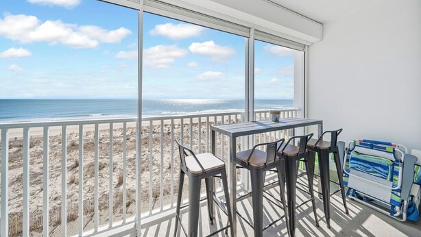 Ein Balkon mit Blick auf Strand und Meer.