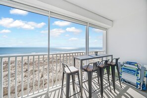Ein Balkon mit Blick auf Strand und Meer.