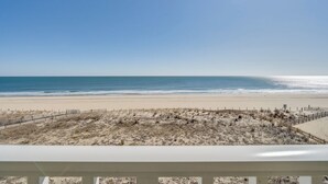 Blick auf einen Strand vom Balkon aus, bewölkter Himmel.