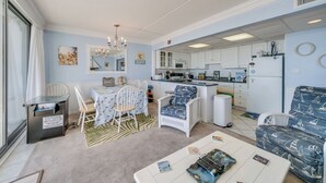 A compact living space with a dining area, kitchenette, and seating area. - Ocean view condo Seaside Vacations & Sales (Ocean City)