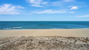 Une plage avec un rivage sablonneux et un ciel bleu dégagé.