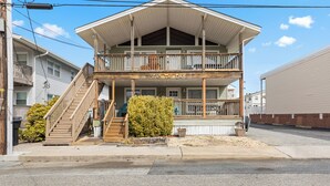 A two-story building with a balcony and a sign that reads "SEAS THE DAY". - Seas the Day 1 by Seaside Vacations & Sales (Ocean City)